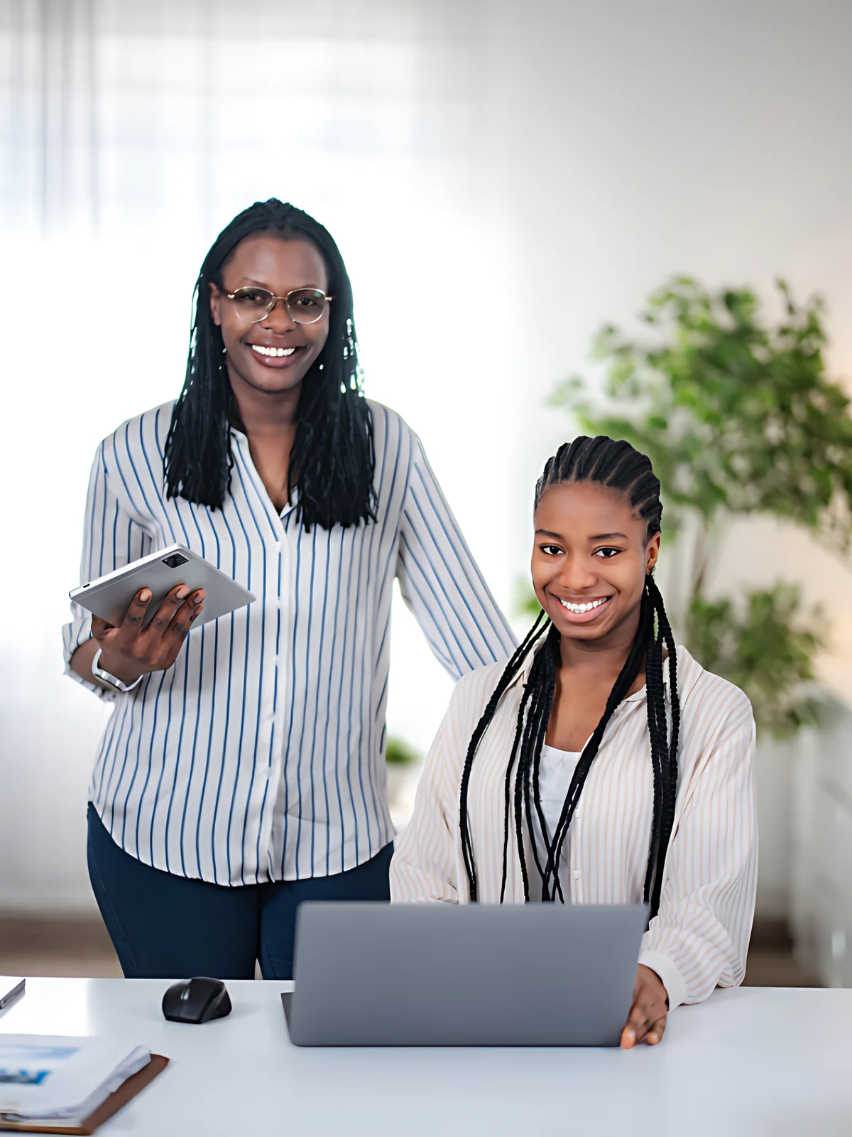 Coach et apprenante souriantes à leur bureau